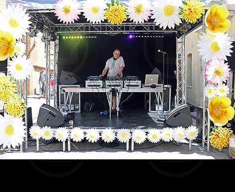 Small covered DJ stage for street event.