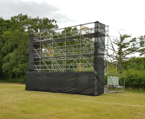 Typical Layher support structure for drive-in cinema screen on grass.